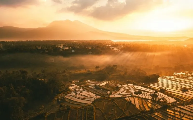 Pretty sunset panorama through clouds with mountain in background.