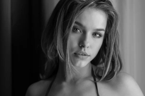 Black and white image of young woman head shot. Seductive look.